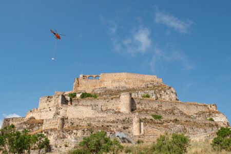 Un helicòpter puja el material a la plaça d’armes per continuar amb les obres al castell de Morella